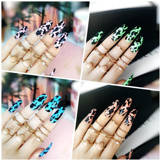 Summer-inspired Deepy Cow nails with black animal patterns in a mix of blue, pink, peach, and green shades