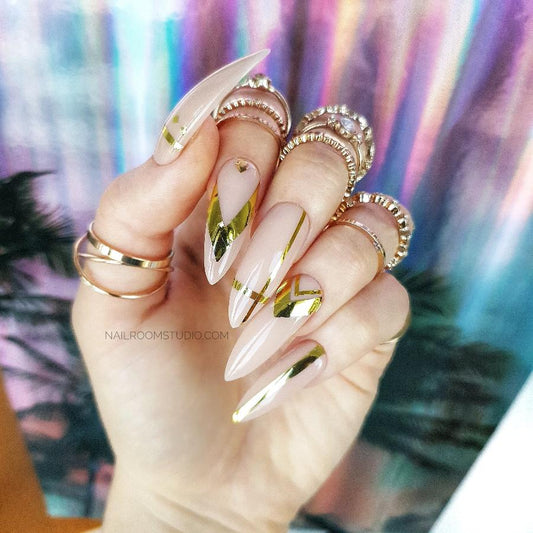 Nude nails with unique golden chrome geometric designs, for a soft, sophisticated look