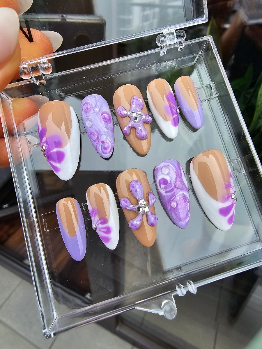 Lilac, nude and purple custom faux nails made in medium size, almond shape and hand made medusa and floral sculpted accents, some nails in white french design