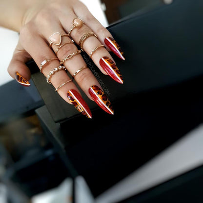 Red nails with reverse leopard and white line details, creating a wild, distinctive look