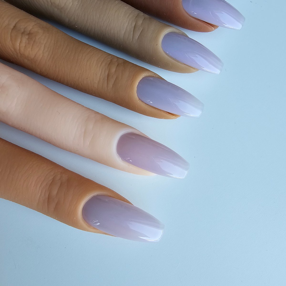 Subtle pastel purple lilac artificial nails in a pigeon shade, versatile and lightly tinted with blue for a unique appeal, picture showing color matching to skin tones color swatches