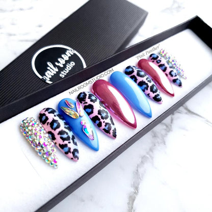 Elegant ombre nails in black luxury packaging, designed with pink and blue panther print and Swarovski crystals for a gender reveal