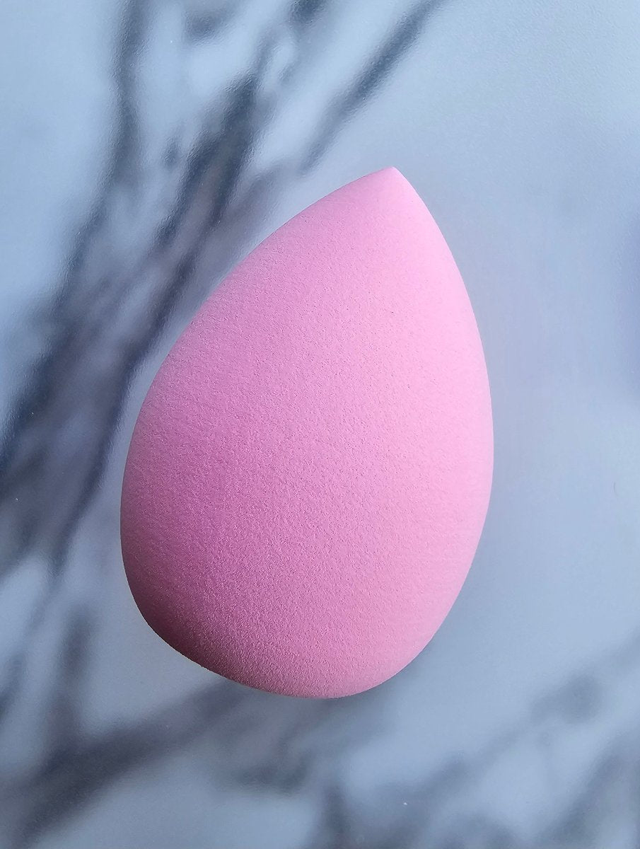 Pink makeup applicator sponge for blending liquid foundation and other cosmetics, providing a smooth and even application