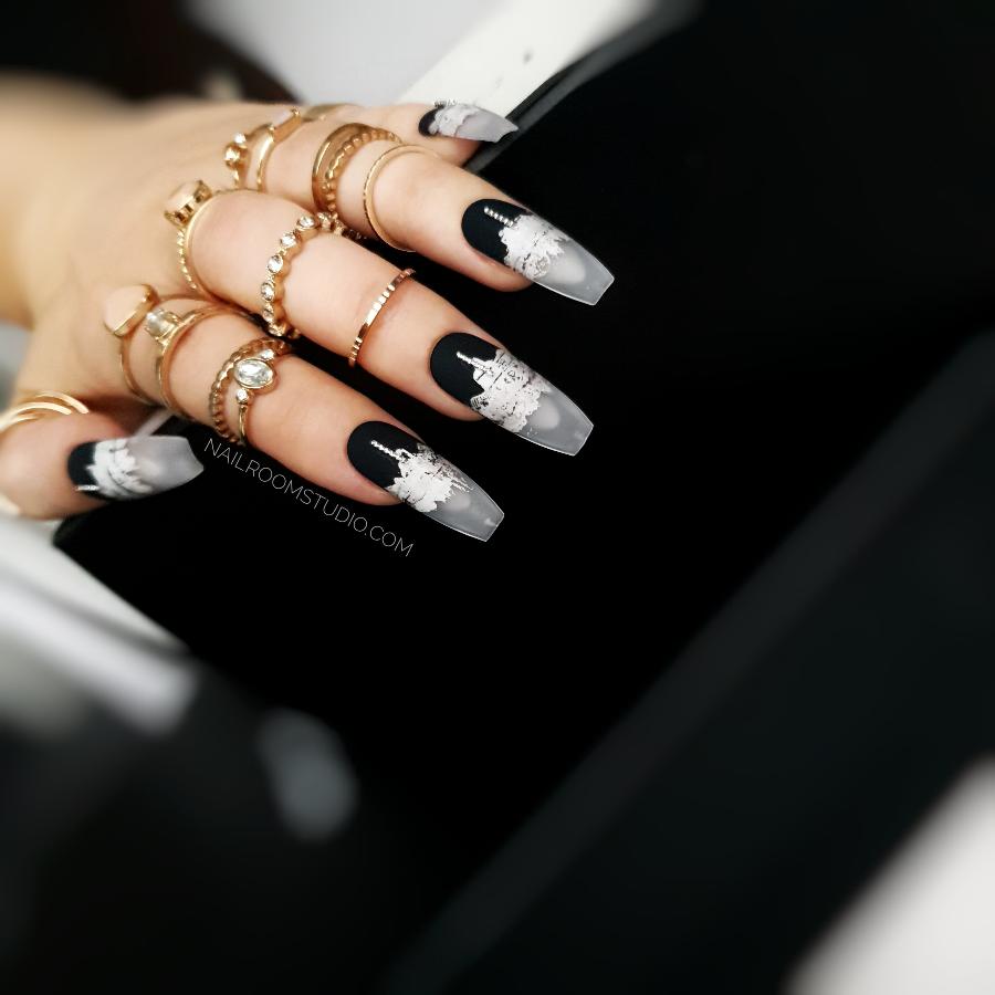 Modern matte black French nails with a silver chrome metallic accent and a frosted transparent tip for a frozen effect