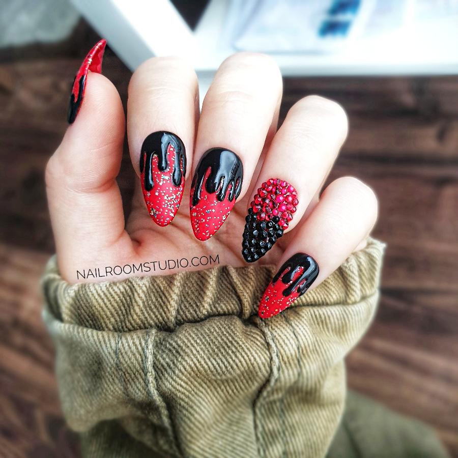 Spooky matte red and black press-on nails with dripping design, glossy black droplets for a ghostly effect, perfect for Halloween, featuring an accent nail adorned with black and deep red Swarovski crystals, displayed on hands