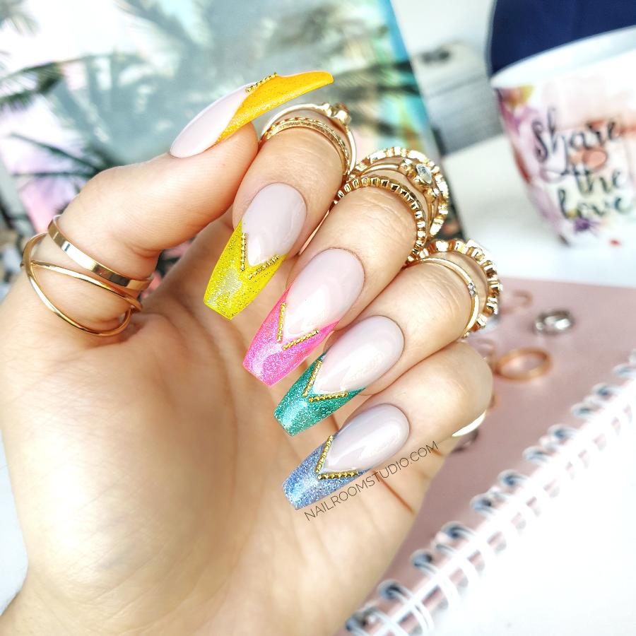 Nude nails with rainbow-colored jelly tips and metallic accents, perfect for a colorful, stylish look