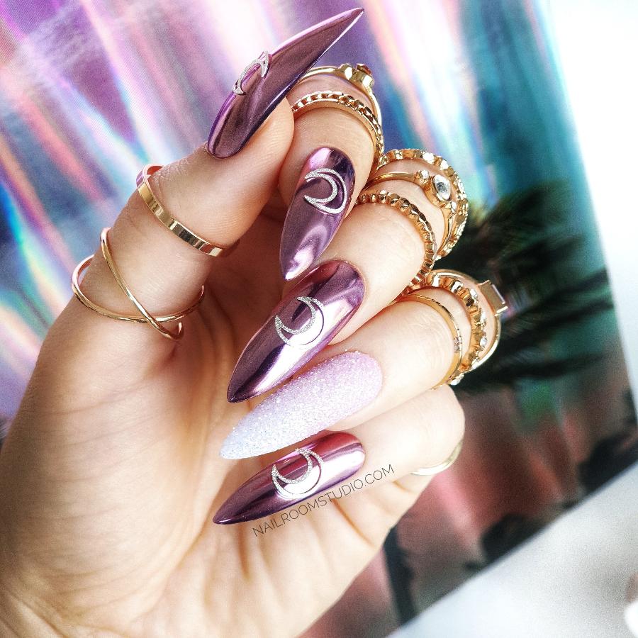 Witchy stiletto nails with pink chrome half-moon and glitter ombre, perfect for a magical Halloween look