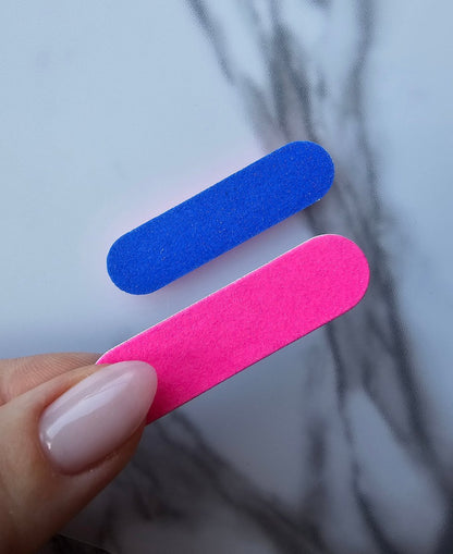 Durable pink and blue double-sided nail file with various grits, perfect for precision filing and smooth nail shaping