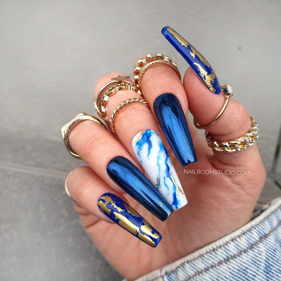 Navy blue deep chrome custom nails with gold chrome accents and hand-painted blue and white marble designs, available in any length