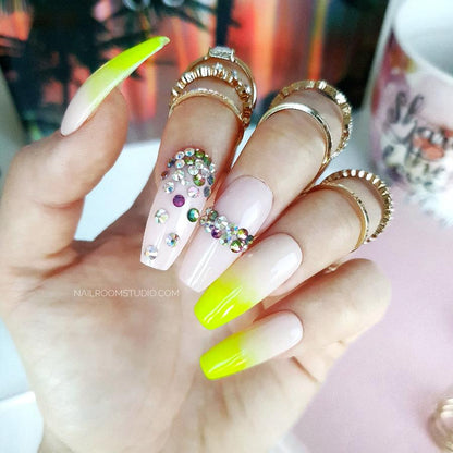 Delicate nude nails featuring a yellow neon ombre with vibrant Swarovski crystal details perfect for summer