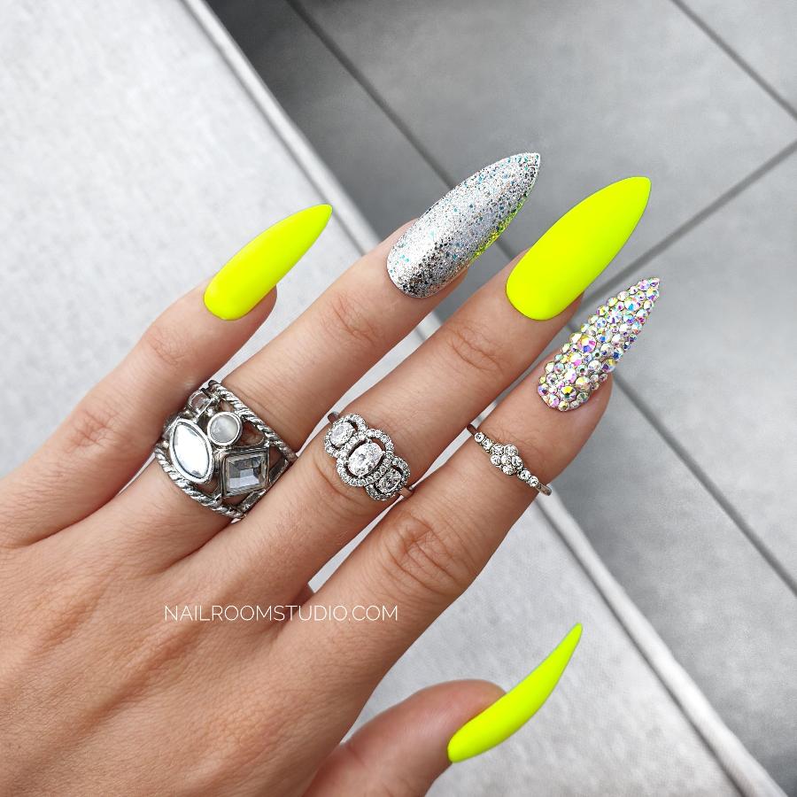 Luxurious matte neon yellow stiletto press-on nails with chrome and silver Swarovski crystal accents, neatly displayed in an elegant black box for a premium presentation