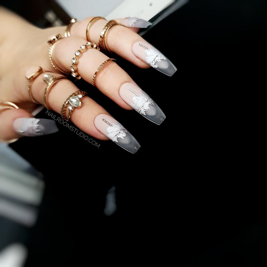 Nude matte nails with a natural tone, complemented by silver details and a partially transparent modern French tip for a frozen look