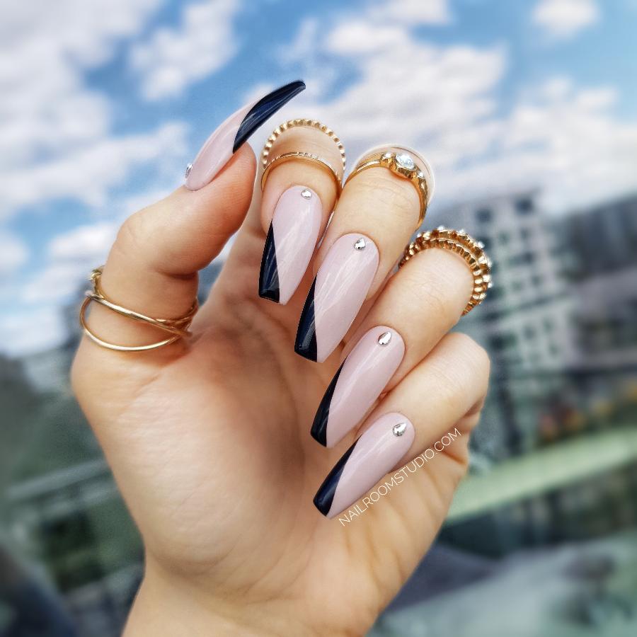 Elegant shiny nude faux nails featuring silver accents and stylish black angled french tips, perfect for any occasion with international shipping