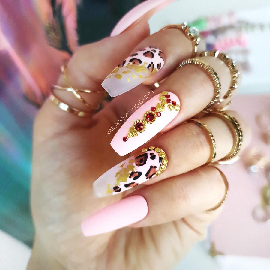 Matte nails with leopard and oriental-inspired designs, including crystals and metal accents, giving a chic, exotic finish