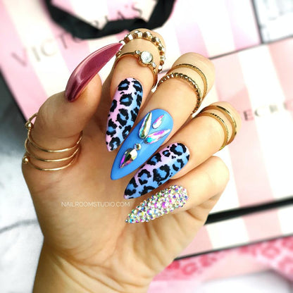 Unique pink and blue ombre nails with panther print, featuring a blend of matte and glossy finishes. Decorated with Swarovski crystals for a fun and stylish gender reveal theme