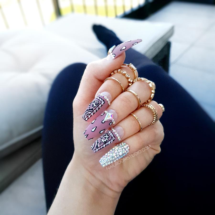 Pink and mauve bandana-themed nails embellished with sparkling crystal details, inspired by traditional bandana patterns with a modern twist