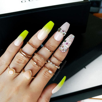 Playful soft nude nails highlighted with yellow neon ombre and colorful Swarovski crystals for a fun design