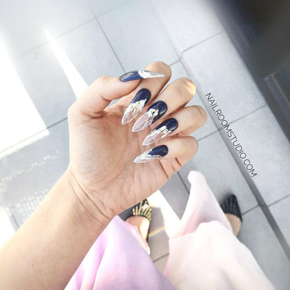 Dark plum press-on nails with a distinctive transparent French tip design, wrapped in silver chrome to mimic molten lava, providing an elegant, one-of-a-kind style, shown on hands