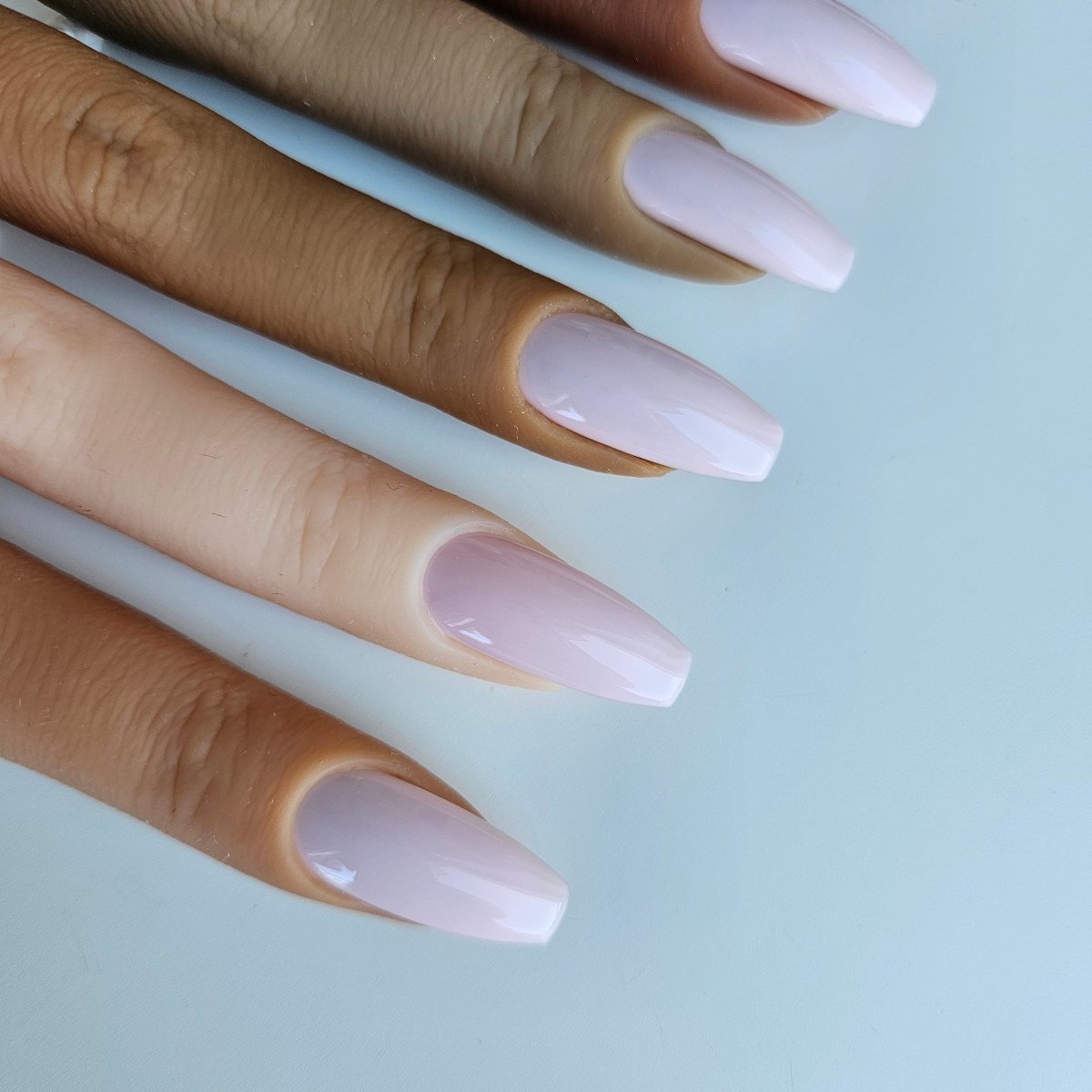 Powder pink press-on nails in a soft, delicate shade, highly opaque and solid color, with high-quality coverage for an elegant and refined look