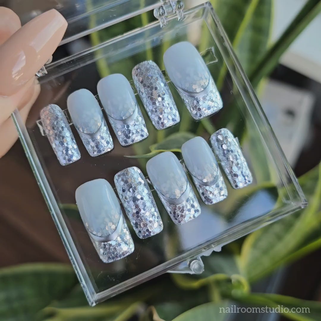 Video showcasing snowy vacation with Press On nails – elegant, winter manicure in nude tones with gold chrome and glitter, captured in a beautiful snowy setting, french ombre nails