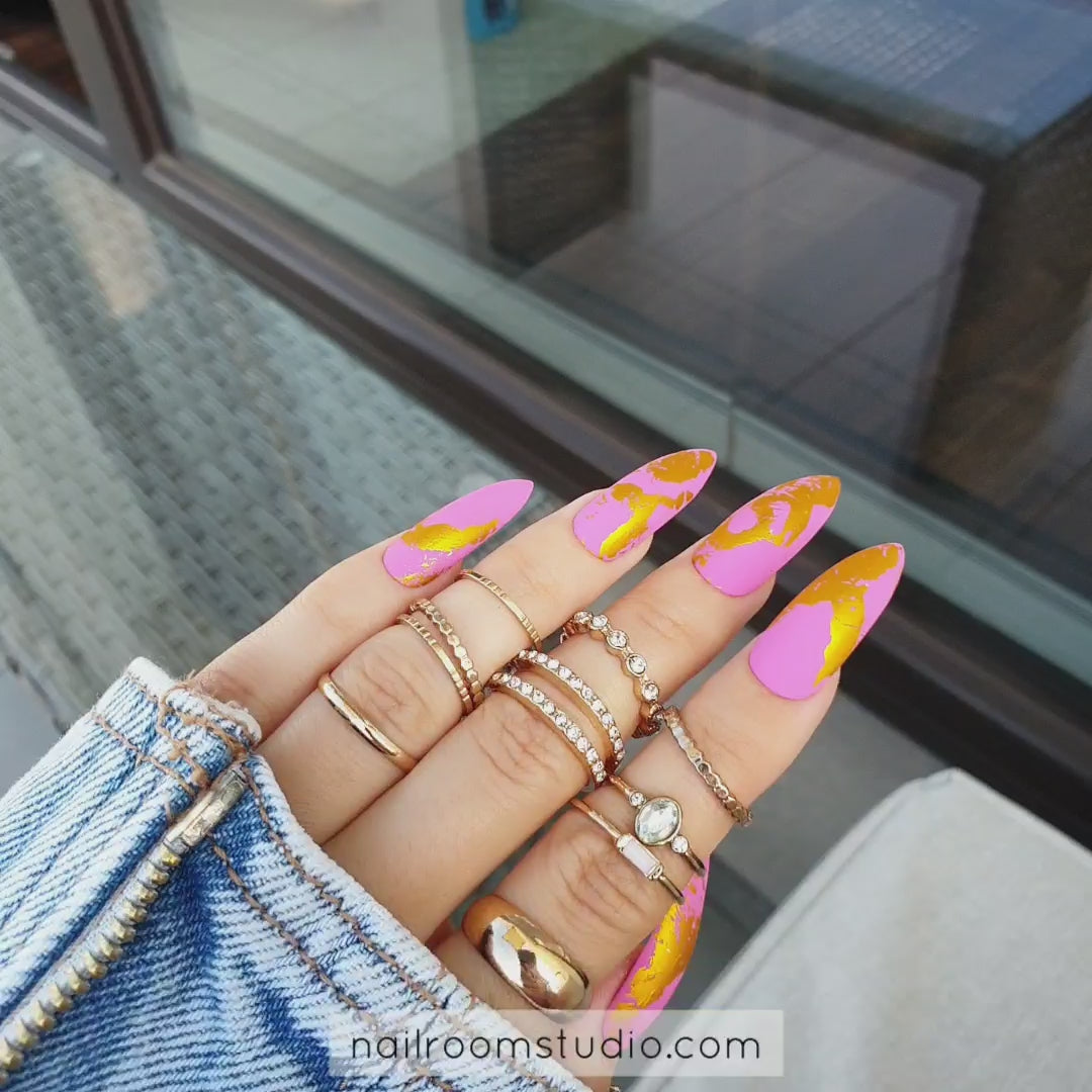 Matte pink nails with bold gold chrome accents, creating a unique, luxurious look by Nail Room Studio