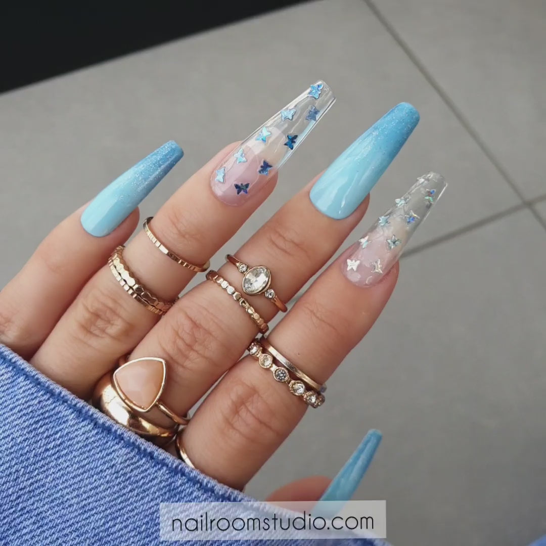 Nail Room Studio gender reveal baby blue ombre nails with glitter, crystals, and butterflies, ideal for baby boy reveal, perfect for both hands and feet, customizable for matching manicure and pedicure sets