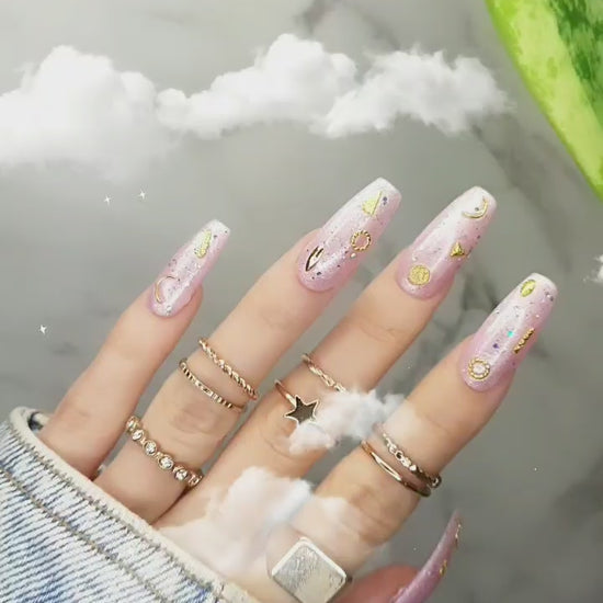 Radiant pink pearl glossy nails with shimmer finish, pearl powder pink for a feminine look, featuring gold 3D moon and star accents, beach side tips