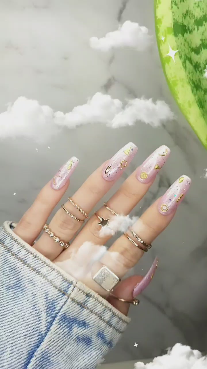 Radiant pink pearl glossy nails with shimmer finish, pearl powder pink for a feminine look, featuring gold 3D moon and star accents, beach side tips