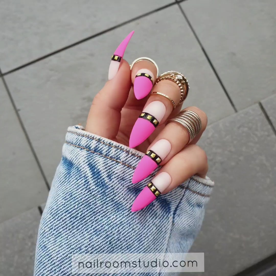 Long steel rose nails in ultra pink with nude tips and bold black and gold accents for kinky lovers from Nail Room Studio, suitable for darker skin tones