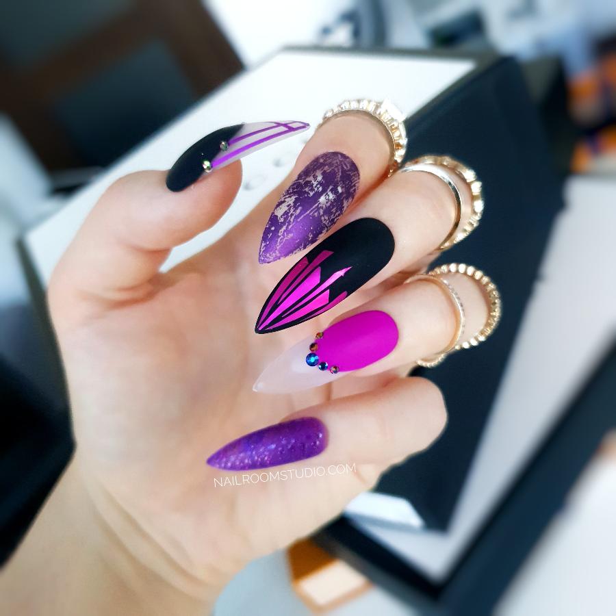 Long matte purple stiletto nails with black chrome accents, raindrop details, and crystals for a mystical, witchy look