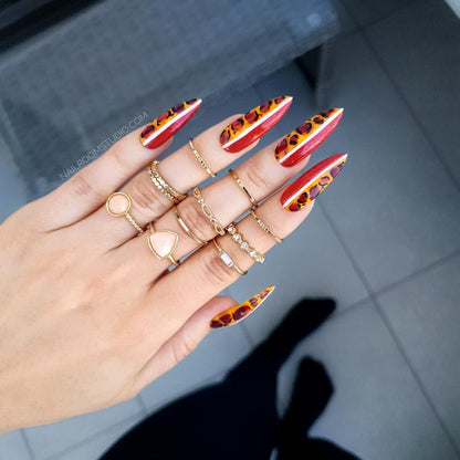 Bold red reverse nails with a leopard print and white line accents, a unique, untamed style