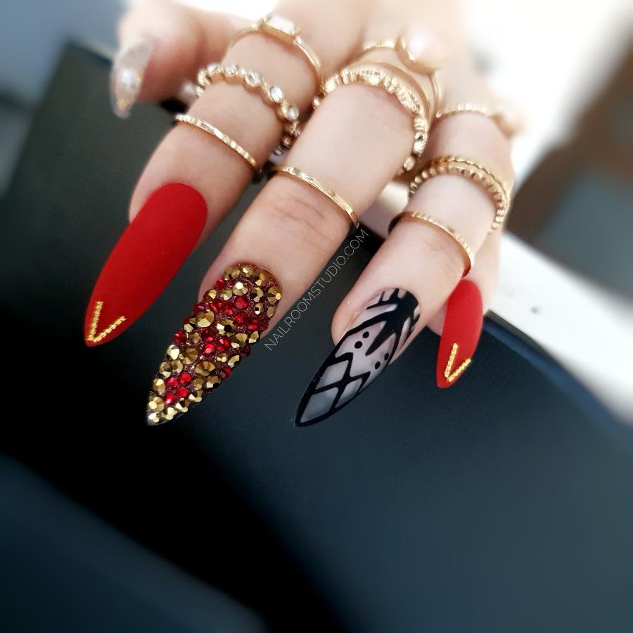 Femme fatale nails in striking red with elegant lace detailing and sparkling red and gold Swarovski crystals finished with chrome accents for a powerful sophisticated style