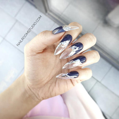 Sophisticated purple press-on nails with silver chrome lava effect on transparent French tips, adding a unique, original touch to the design, displayed on hands