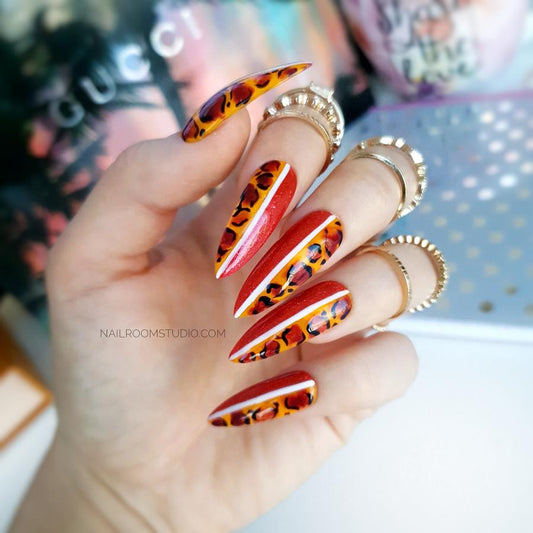 Unique red nails with a reverse style, leopard print, and white lines, embodying an untamed and daring look