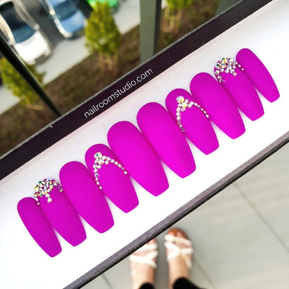 Vibrant matte purple press-on nails featuring stunning opalescent Swarovski crystal accents. Long length with customizable options available for shipping to the USA