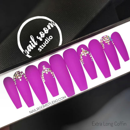 Matte finish vibrant neon purple press-on nails adorned with beautiful opalescent Swarovski crystals arranged in a stunning pattern. Long nails with options for length, size, and shape, available for shipping to the USA