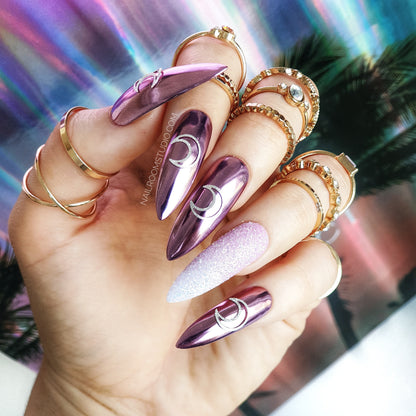 Long stiletto nails with glitter ombre and pink champagne moon accents, a bold witchy look with chrome highlights